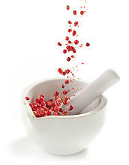 Image showing red peppercorns falling into mortar and pestle