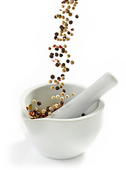 Image showing various peppercorns falling into mortar and pestle