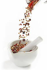 Image showing various spices falling into mortar and pestle