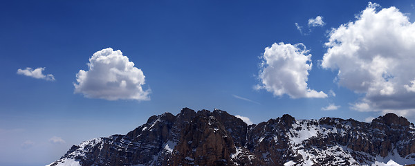 Image showing Panorama of snowy rocks and blue sky with clouds