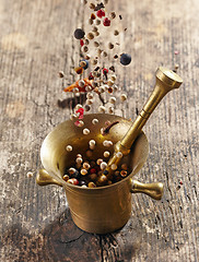 Image showing various spices falling into mortar and pestle