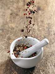 Image showing various spices falling into mortar and pestle