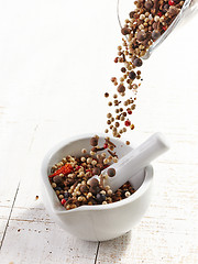 Image showing various spices falling into mortar and pestle