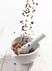 Image showing various spices falling into mortar and pestle