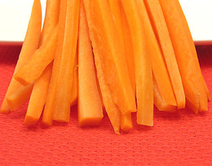 Image showing Julienne carrots on a white plate and red placemat