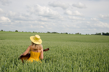 Image showing Country woman in dress play guitar wheat field 