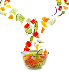 Image showing Fresh vegetables falling into the glass bowl