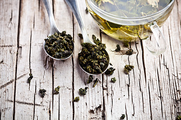 Image showing cup of green tea and spoons 