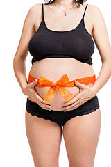 Image showing Pregnant woman wearing a bow on her belly