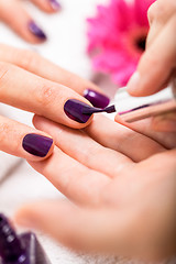 Image showing Woman having a nail manicure in a beauty salon