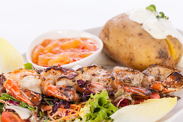 Image showing Grilled prawns with endive salad and jacket potato