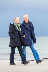 Image showing happy elderly senior couple walking on beach