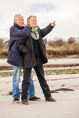 Image showing happy elderly senior couple walking on beach