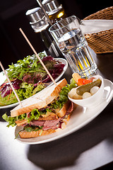 Image showing Delicious pastrami club sandwich and pickles