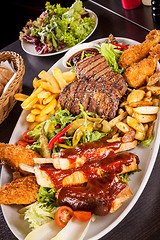 Image showing Platter of mixed meats, salad and French fries