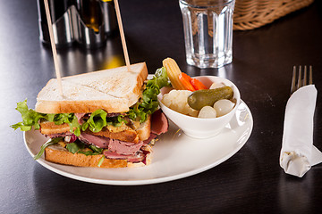 Image showing Delicious pastrami club sandwich and pickles