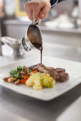 Image showing Chef plating up food in a restaurant