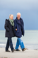 Image showing happy elderly senior couple walking on beach