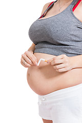 Image showing Pregnant woman breaking a cigarette in two