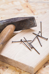 Image showing Mallet with nails and planks of new wood