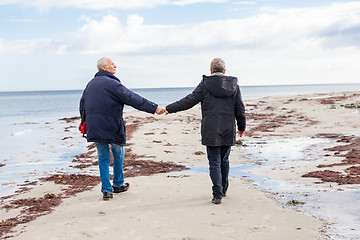 Image showing happy elderly senior couple walking on beach