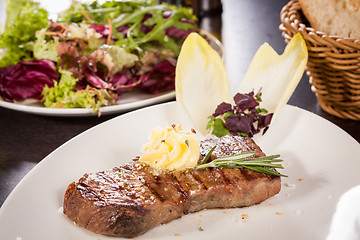 Image showing Grilled beef steak topped with butter and rosemary