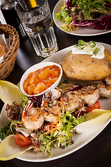 Image showing Grilled prawns with endive salad and jacket potato