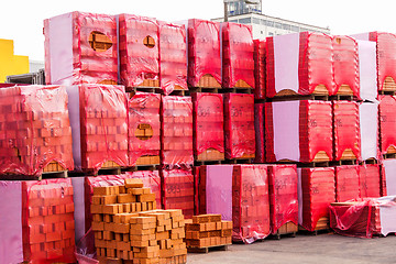 Image showing Red clay bricks stacked on pallets