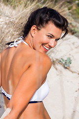 Image showing Beautiful woman sitting on golden beach sand