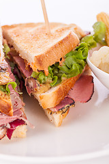 Image showing Delicious pastrami club sandwich and pickles