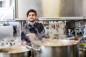 Image showing Chef cooking a vegetables stir fry over a hob