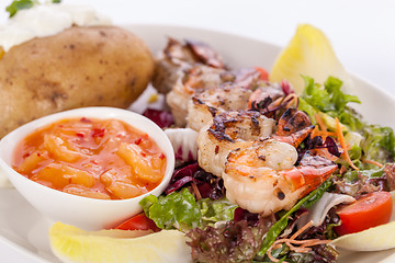 Image showing Grilled prawns with endive salad and jacket potato