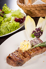 Image showing Grilled beef steak topped with butter and rosemary