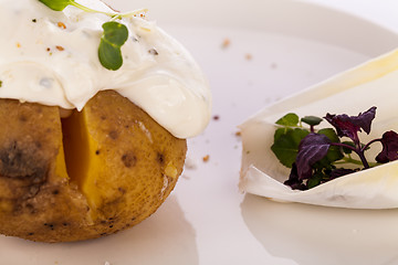 Image showing Baked jacket potato with sour cream sauce