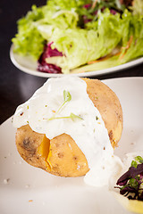 Image showing Baked jacket potato with sour cream sauce