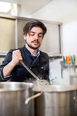 Image showing Chef cooking a vegetables stir fry over a hob