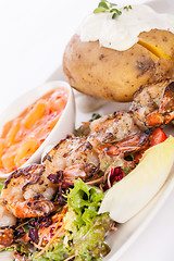 Image showing Grilled prawns with endive salad and jacket potato