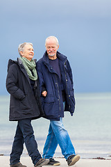 Image showing happy elderly senior couple walking on beach