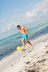 Image showing Mature man kicking ball