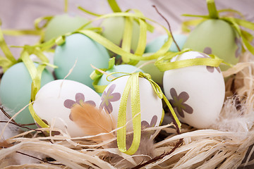 Image showing Colourful green Easter eggs in straw