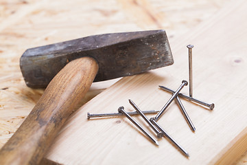 Image showing Mallet with nails and planks of new wood