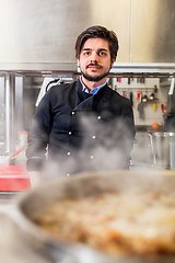 Image showing Chef cooking a vegetables stir fry over a hob