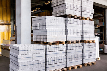 Image showing Red clay bricks stacked on pallets