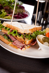 Image showing Delicious pastrami club sandwich and pickles