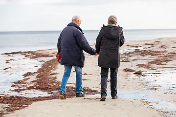 Image showing happy elderly senior couple walking on beach