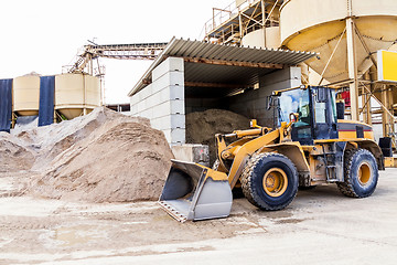 Image showing Parked pay loader near pile of dirt