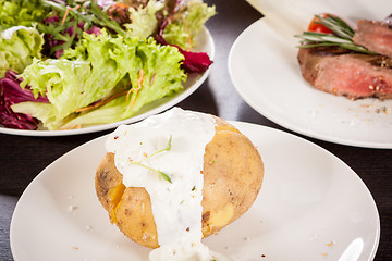 Image showing Baked jacket potato with sour cream sauce