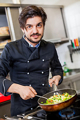 Image showing Chef cooking a vegetables stir fry over a hob