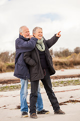 Image showing happy elderly senior couple walking on beach