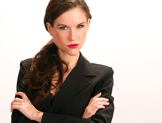 Image showing Focused Business Woman Peers at Viewer Arms Crossed on White